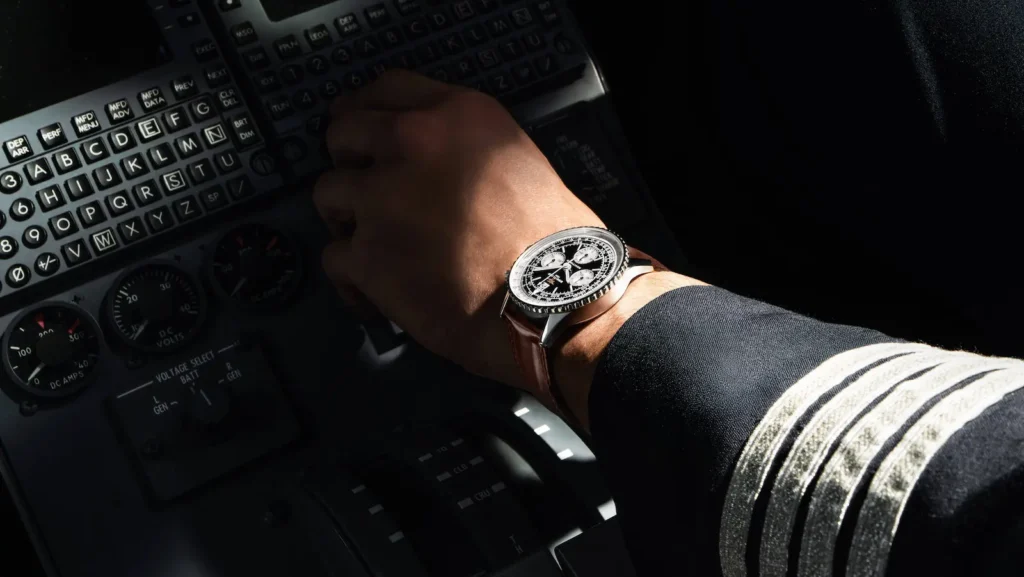 Breitling Navitimer B09 e Cosmonaute Navitimer B09 Chronograph 41 nero al polso di un pilota, nella cabina di un aereo